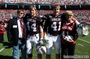 Dusty (44) and Jordy Lindsey (41) share a moment with their parents at South Carolina Senior Day last Saturday. The twins have been bashing heads alongside each other since their days playing football for the Mobile, Ala., Mims Park Redskins, where their Dad was a coach.